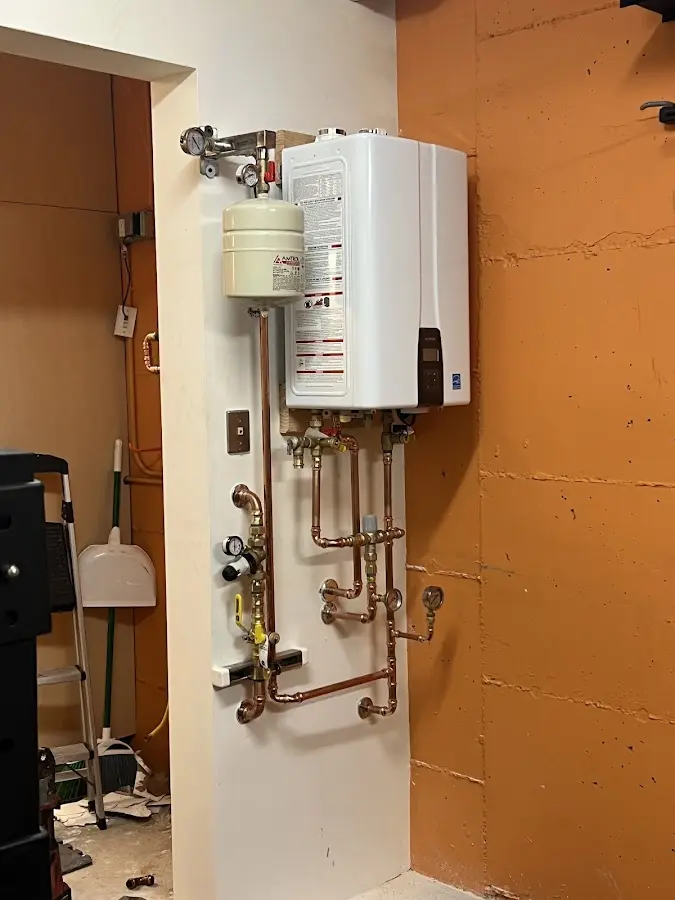 Plumbing technician inspecting water heater connections in Carthage